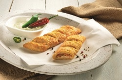 Frischkäse-Pepperoni-Stange, aufgebacken aus dem Tiefkühler, auf einem weißen Teller mit Deko