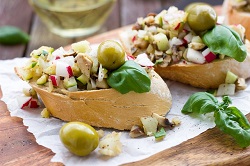 Veggie und vegan_auf dem Bild sind zwei gefüllte backwaren zu sehen. Die Füllung besteht aus oliven, käse, geraspelten Radischen und Basilikum.