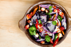 Eine vegetarische Bowl bestehend aus Zwiebeln, Paprika, Gurken und weiterem Gemüse