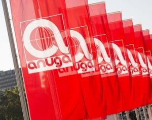 Auf dem Foto sind mehrere rote Fahnen hintereinander zu erkennen, die das Logo der Branchenfachmesse Anuga haben