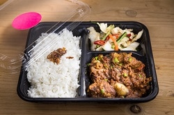 Food Impact_Delasia_Auf dem Bild sieht man China food in einer to go Verpackung welche einer dreier Aufteilung hat. Diese besteht aus Reis, Gemüse und Fleisch in Soße.
