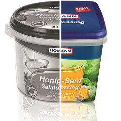 Homann Salatdressing- Verpackungen von den Sorten: Joghurt Kräuter und Kräuter Dressing. Beide stehen nebeneinander auf hellem Hintergrund und Spiegln sich vorne im Bild