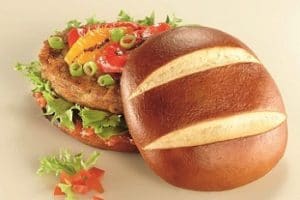 Auf dem Bild ist ein Burger zu erkennen, dessen Burger Brot aus Laugenbrot besteht. Der Burger ist mit Salat, Lauchzwiebeln und Ketchup belegt.