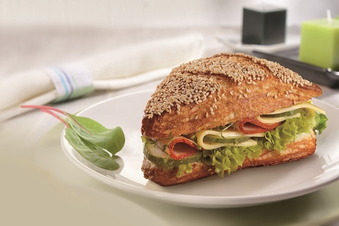 Ein Sandwich belegt mit Salami, Käse und Salat
