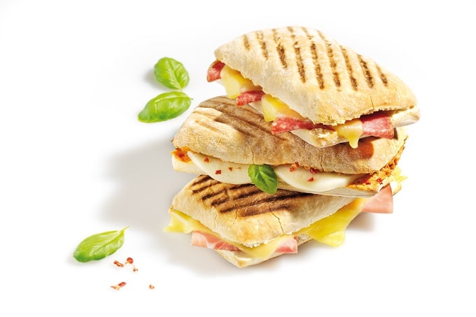 Drei Sandwiches aufeinander belegt mit Salami, Schinken, Käse und Ei.