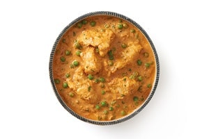 Themenwelt Hot Snacks, dieses bild zeigt ein Indisches Curry mit Hühnchen und Erbsen. Es ist von dem Hersteller Food Impact und wird unter der Marke Delasia verkauft