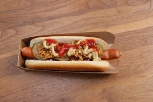 Auf dem Bild ist ein dänischer Hot Dog in einer Kartonverpackung von Bionatic zu sehen.