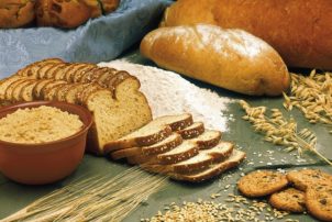 Auf dem Bild sind verschiedene Sorten von Broten sowie Getreide und Mehl zu sehen.