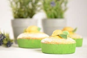 Drei Muffins eingehüllt in grünen Backformen.