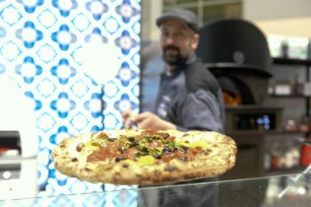Convenience Food fertige Pizza Mann im Hintergrund 