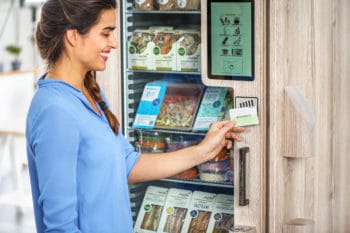 Frau am Automaten Bezahlung mit Karte