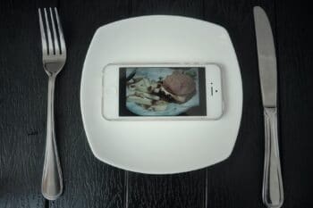 Burger im Smartphone auf einem Teller