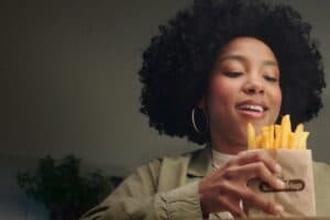 Frau mit Pommes Frites in der Hand