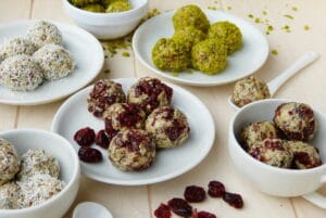 Verschiedene Sorten Energieballs auf Tellern mit Superfoods / snackconnection