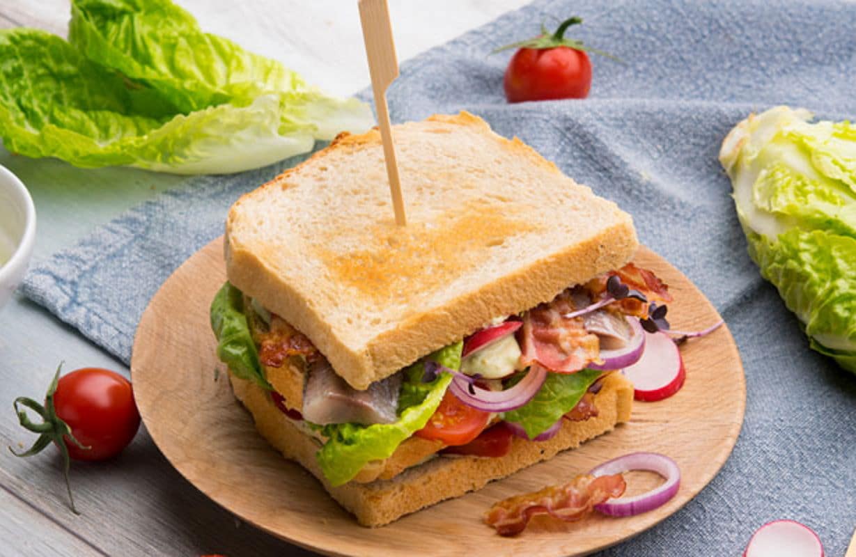 Club Sandwich mit Gemüse, Salat und Bacon / snackconnection