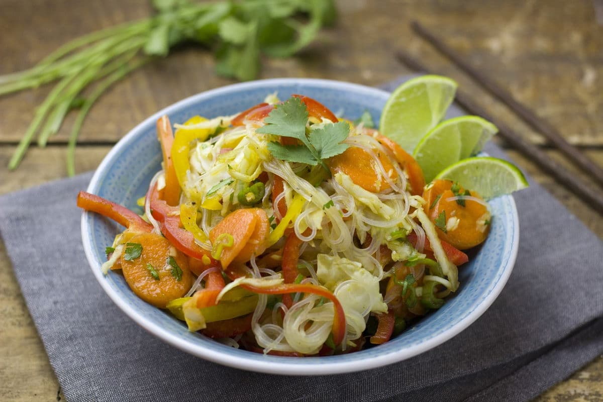 Rezept:  Frischer Glasnudelsalat mit Karotten, Hühnerbrust und Shrimps, serviert auf Salatblättern und mit Jasmin-Reis.