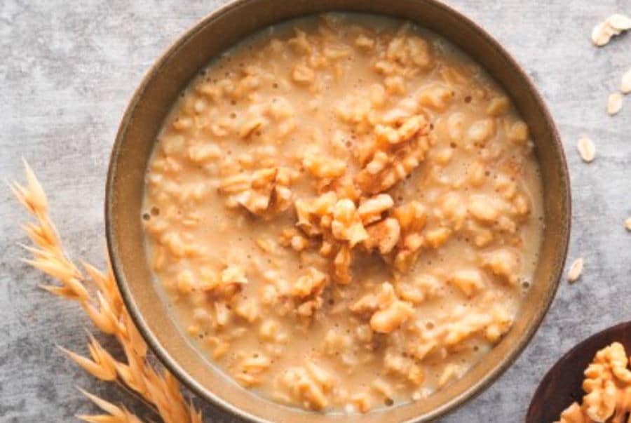 Rezept: Leckerer veganer Porridge mit Apfel-Haselnuss Geschmack und Nuss-Topping für gemütliche Tage im Herbst.