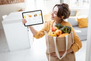 Frau mit einkaustüte und table / Online shopping