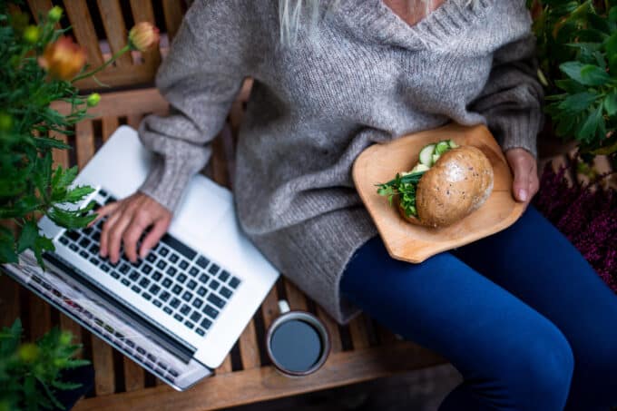 Frau mit Laptop essen vegan Burger