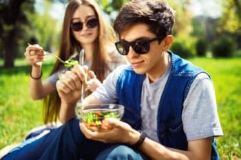 Junge Leute Essen Salat im Park